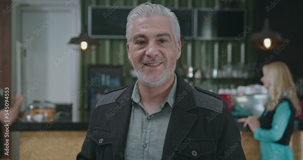 Portrait of a mature entrepreneur holding tablet standing at coffee shop smiling at camera Portrait of a mature entrepreneur holding tablet standing at coffee shop smiling at camera
