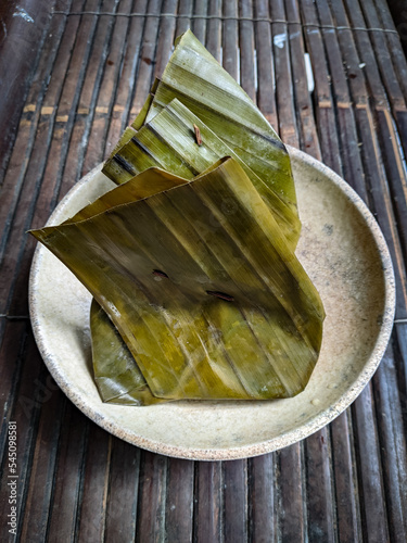 Botok,indonesian traditional food made from sliced tempeh,chinese petai,basil mixed with grated coconut seasoned and wraped in banana leaves and then steamed photo