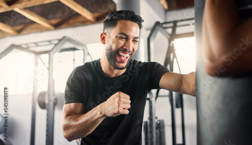 Obraz na plátně Boxing gym, fitness and happy athlete boxer punching a training bag in a martial arts studio or club