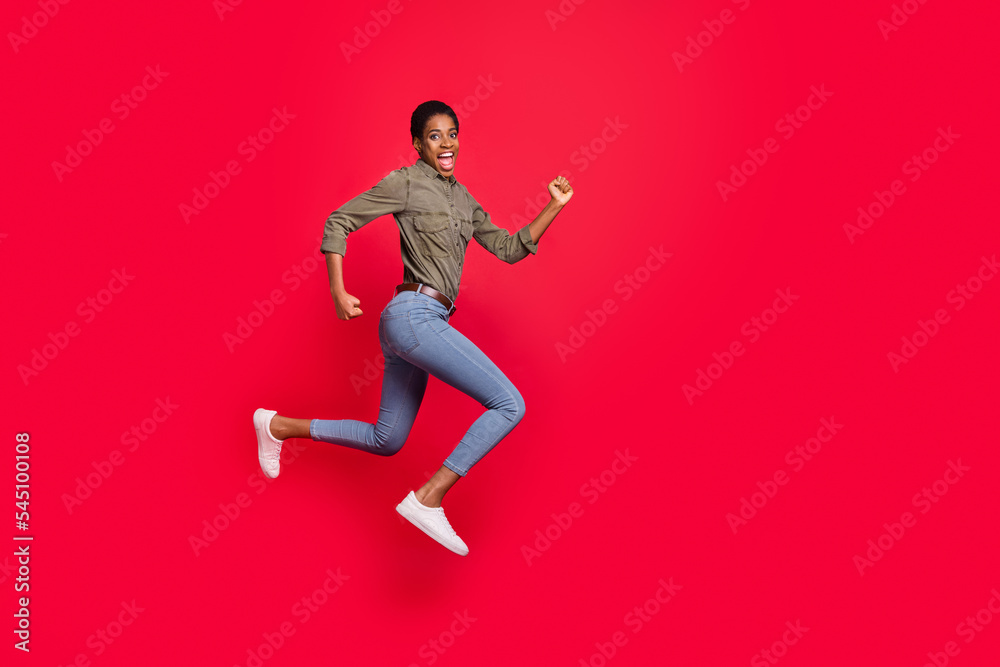 Full length body size view of attractive trendy girl jumping running having fun isolated over vivid red color background