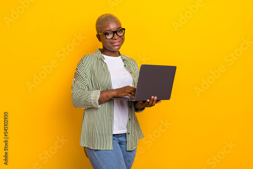 Portrait of nice positive person hold use wireless netbook coworking isolated on yellow color background