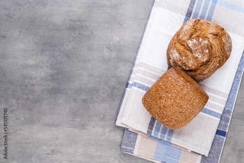 Gold rustic crusty loaves of bread and buns on wooden background. Still life captured from above top view, flat lay.