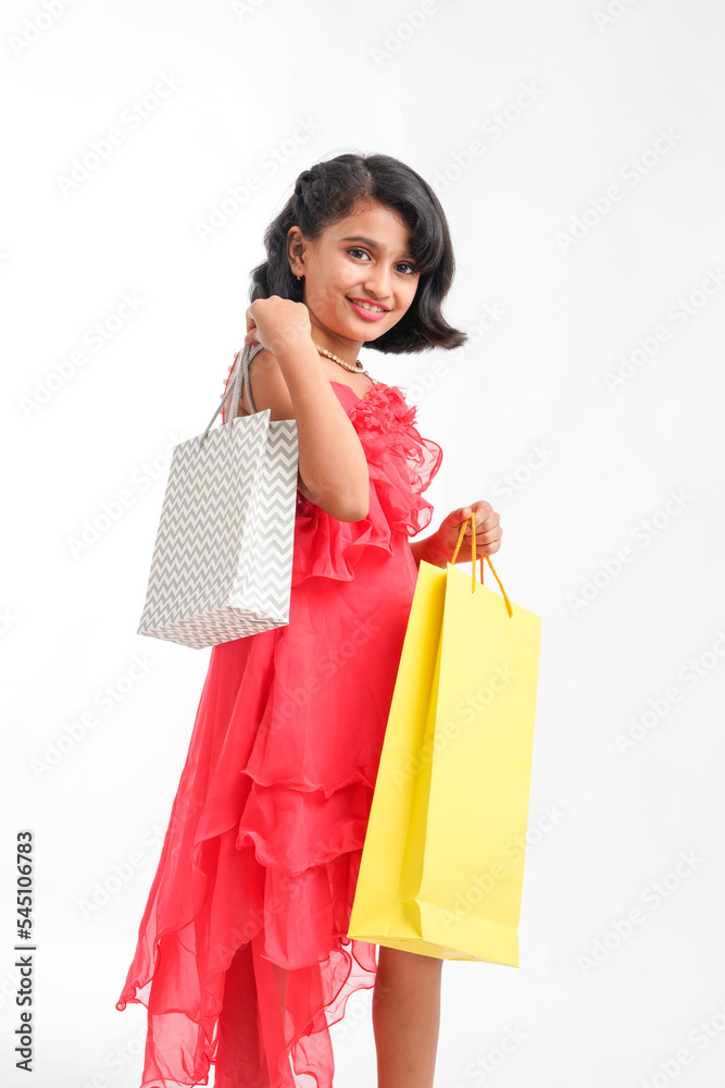 Happy Indian little girl holding shopping bags on white background. Happy Indian little girl holding shopping bags on white background.