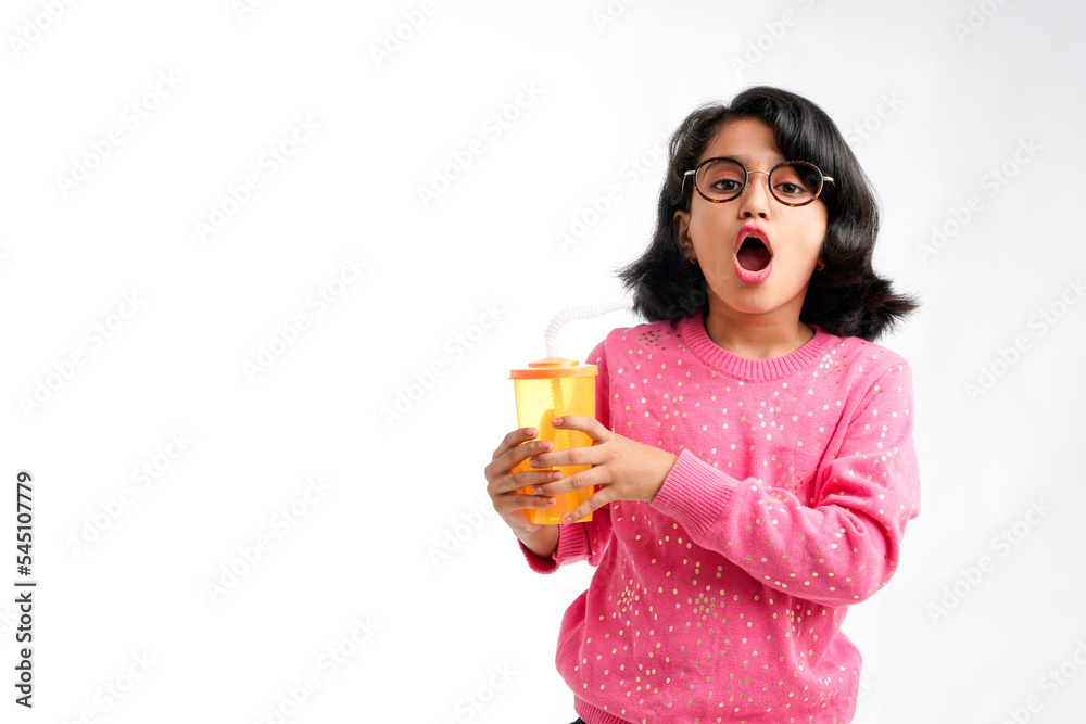 Indian happy little girl drinking juice