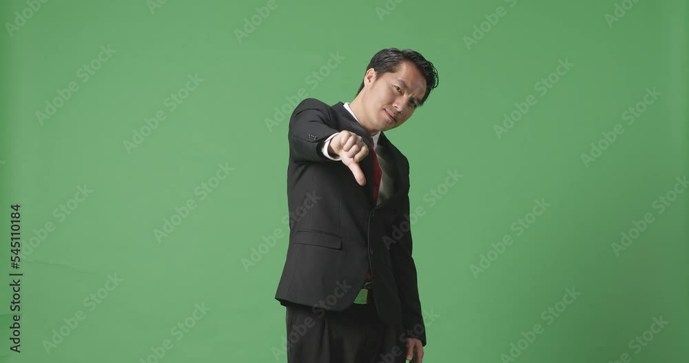 Asian Business Man Showing Thumbs Down Gesture While Standing In The Green Screen Studio
Asian Business Man Showing Thumbs Down Gesture While Standing In The Green Screen Studio