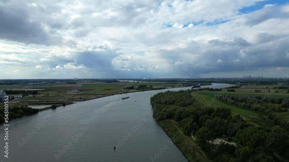 View of Schelda river in Zwijndrecht, Belgium with cargo ship sailing View of Schelda river in Zwijndrecht, Belgium with cargo ship sailing