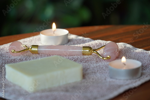 Fototapeta Naklejka Na Ścianę i Meble -  spa still life with candles, handmade natural soap, towel, and pink jade roller