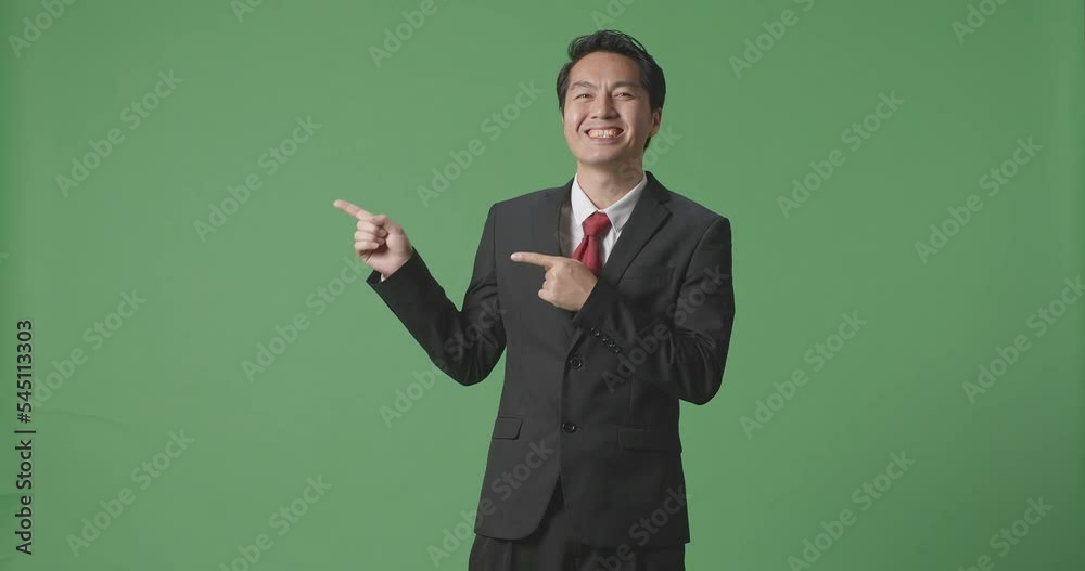 An Asian Business Man With A Smile Pointing To The Side While Standing In The Green Screen
An Asian Business Man With A Smile Pointing To The Side While Standing In The Green Screen