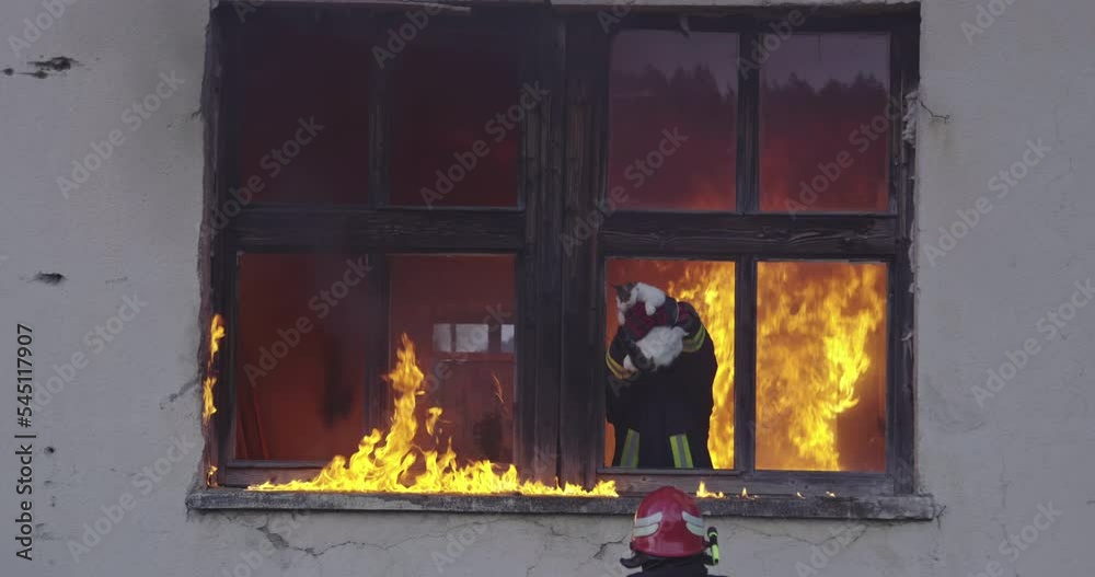 Firefighter hero carrying baby girl out from burning building area from fire incident. Rescue people from dangerous place