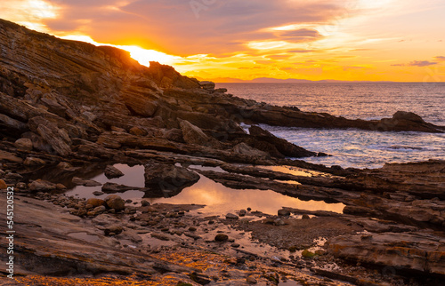 Orange sunset on the coast of Mount Jaizkibel next to a river next to San Sebastian, Basque Country