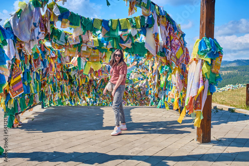 Wallpaper Mural A girl walks under an arch with traditional Buddhist prayer flags in the Rinpoche Bagsha datsan in Ulan-Ude city of the Republic of Buryatia, Russia. Torontodigital.ca