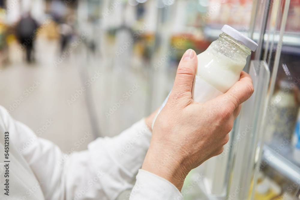Hand eines Kunden beim Einkaufen von Mandelmilch