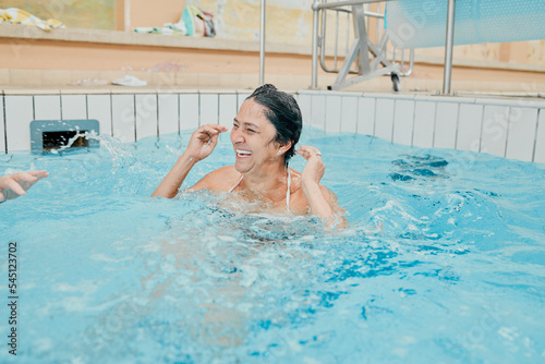 Retirement  happy and wellness woman swimming in pool for pension leisure fun with smile. Cardio health lifestyle of senior person in swimming pool for exercise  fitness and happiness.