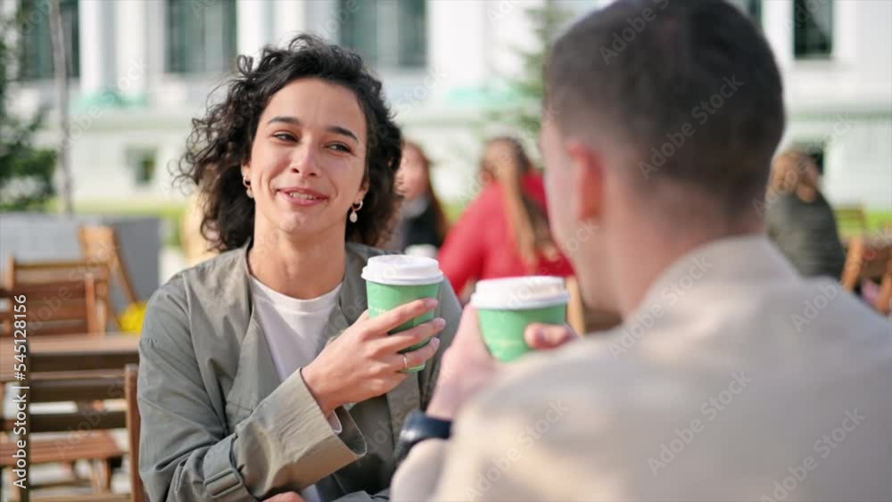 A happy couple outdoors near a cafe. Looking at each other, smiling and talking, coffee. Autumn atmosphere. Slow motion A happy couple outdoors near a cafe. Looking at each other, smiling and talking, coffee. Autumn atmosphere. Slow motion