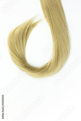 Blond natural hair on white background. Piece of blonde hair on white background. Hairdresser service, hair strength, haircut, hairstyle.