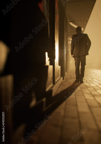 Man in suit walks on sidewalk along buildings in a misty city. Rear view. 3D render.
