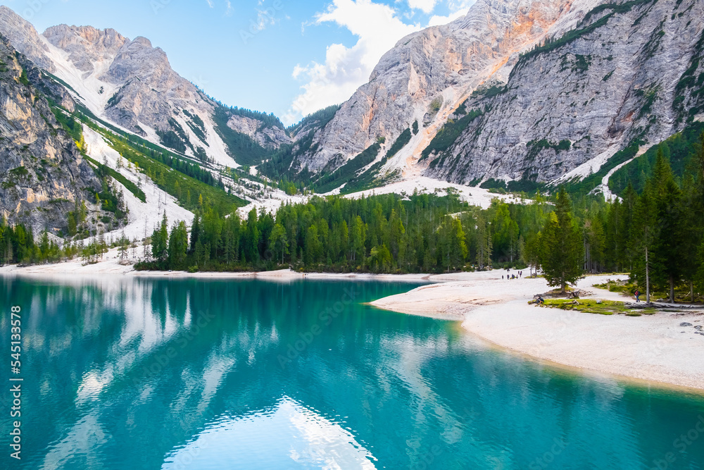 Sunny day on Lake Braies with turquoise water and high Dolomites mountains. 