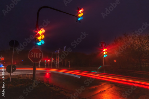 Traffic lights on a traffic junction in a rainy night