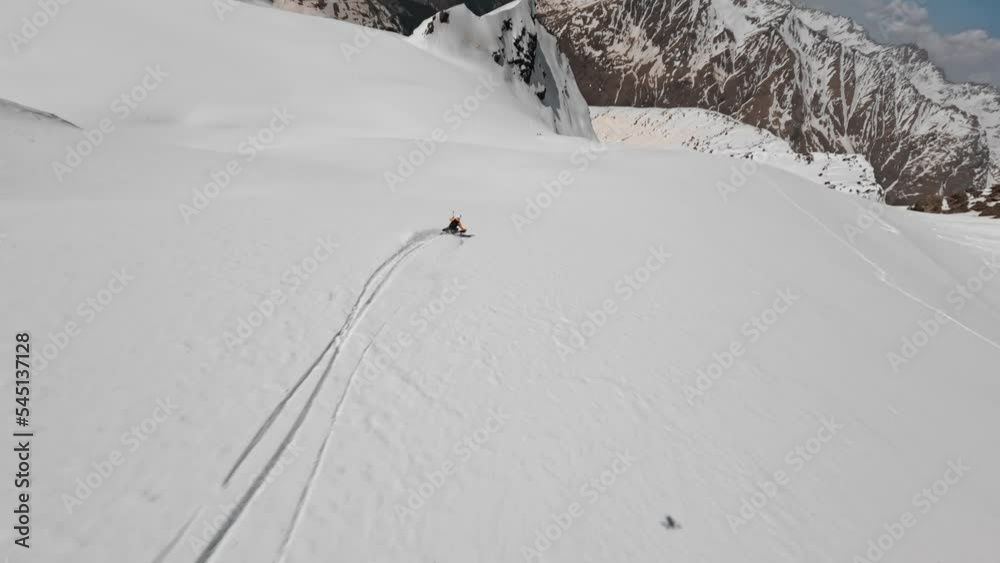 FPV sport drone follow male skier in yellow jacket freeride downhill extreme speed movement from glacier at winter mountain. Aerial view ski sportsman riding snow cliff slope frozen outdoor hobby 4k FPV sport drone follow male skier in yellow jacket freeride downhill extreme speed movement from glacier at winter mountain. Aerial view ski sportsman riding snow cliff slope frozen outdoor hobby 4k