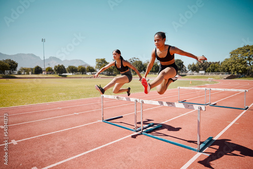 Sport, jump and women runner doing hurdles on stadium track, athlete running race and fitness training outdoor. Practice, workout and sports, speed and agility for exercise and cardio motivation. photo