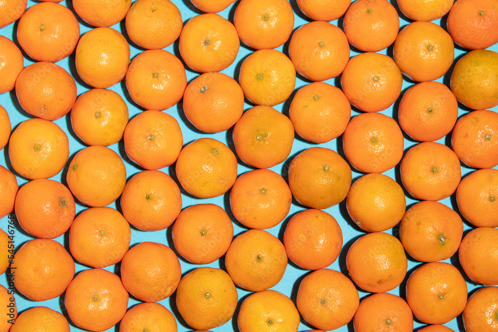 Juicy and healthy mandarins, messy, on a blue background, forming a pop art style texture