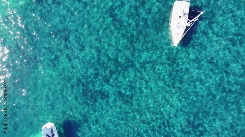 Flying over little boats and people swiming in clear watter, up to the port of Saint Honorat island part of the Iles de Lérins, next to Cannes in south of France in mediterranean sea Flying over little boats and people swiming in clear watter, up to the port of Saint Honorat island part of the Iles de Lérins, next to Cannes in south of France in mediterranean sea