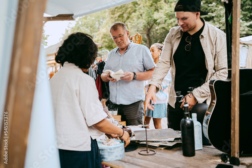 Customers buying products while shopping at flea market