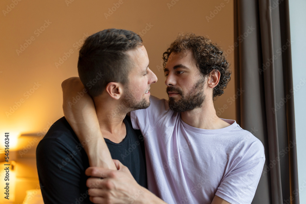 Obraz premium Two young man lgbtq gay couple dating in love hugging enjoying intimate tender sensual moment together kissing with eyes closed