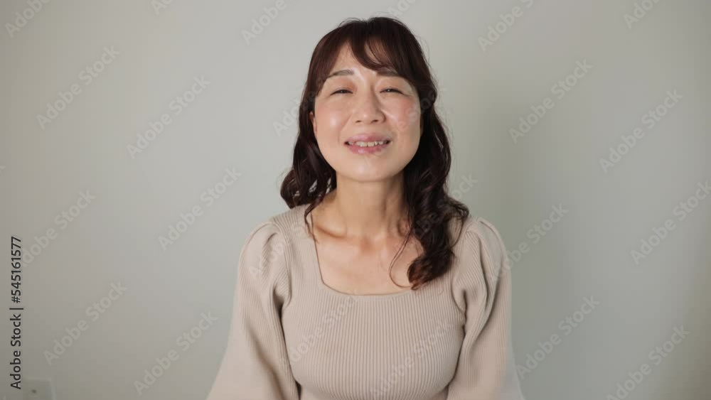 Asian woman takes off her mask and smiles. Dolly out. 25P Asian woman takes off her mask and smiles. Dolly out. 25P