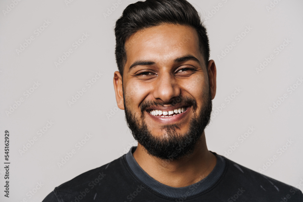 Young indian man with beard smiling and looking at camera Young indian man with beard smiling and looking at camera