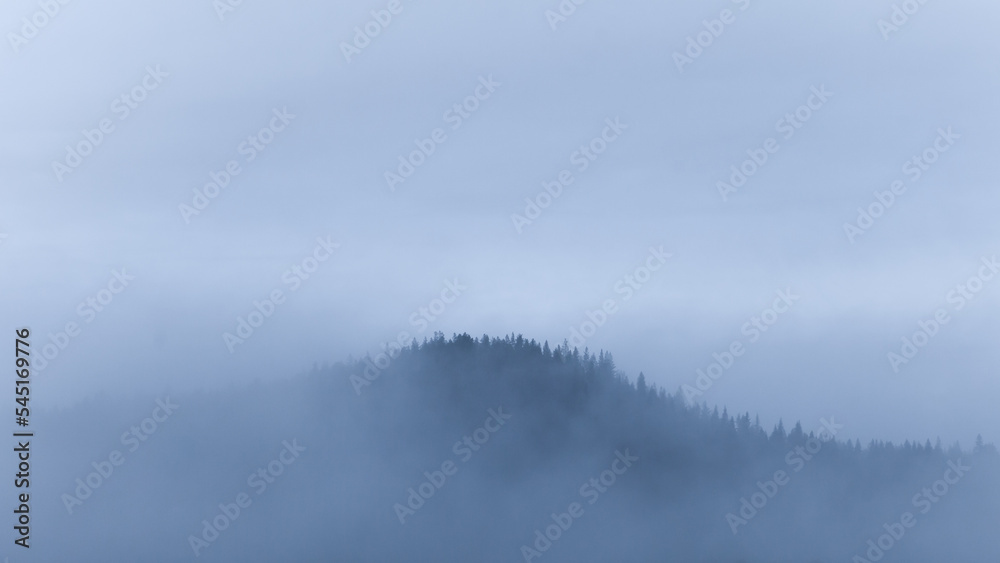 Small mountain covered in fog