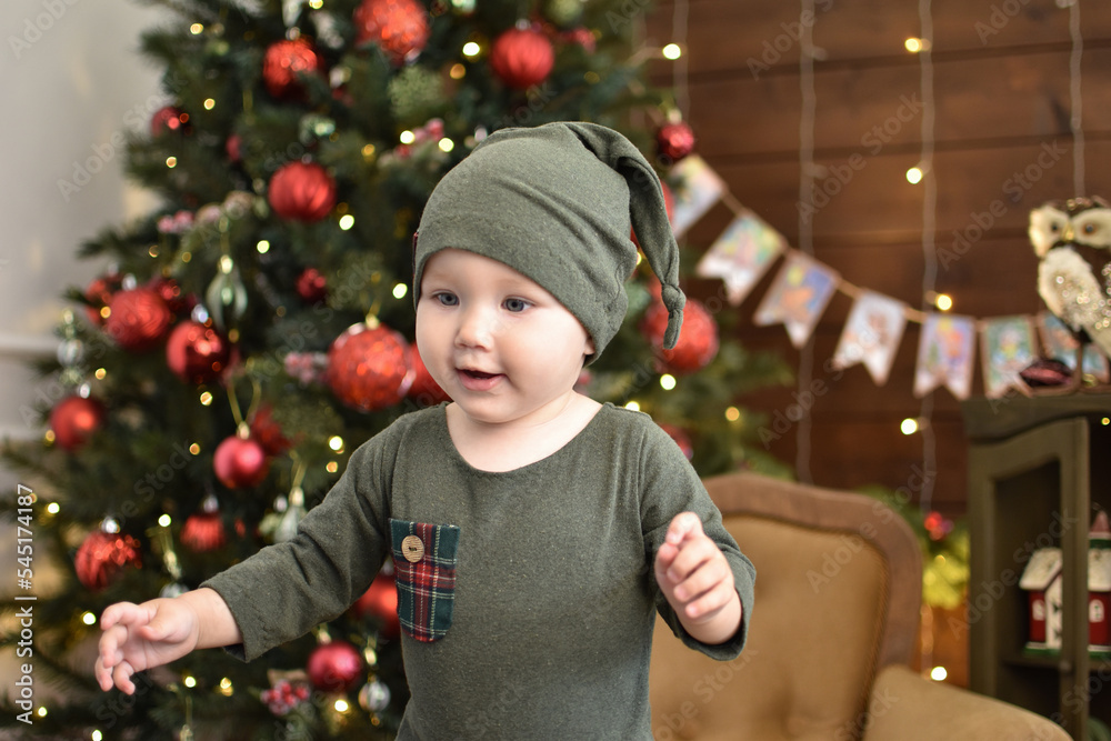 Cute little baby against blurred lights on dark background. Christmas celebration Cute little baby against blurred lights on dark background. Christmas celebration