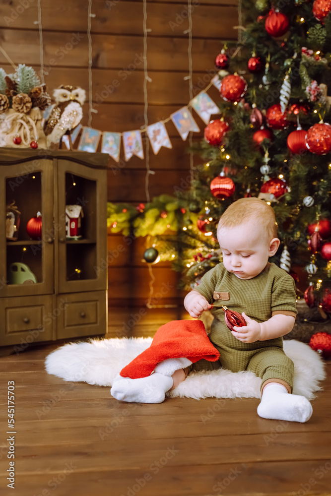 Cute little baby against blurred lights on dark background. Christmas celebration Cute little baby against blurred lights on dark background. Christmas celebration