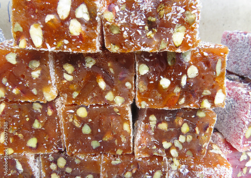 Traditional Turkish delicacies. Varieties of Turkish Delight with Pistachio.Turkish delight sweet cubes background. Lokum sprinkled with sugarin , display at a street food market photo