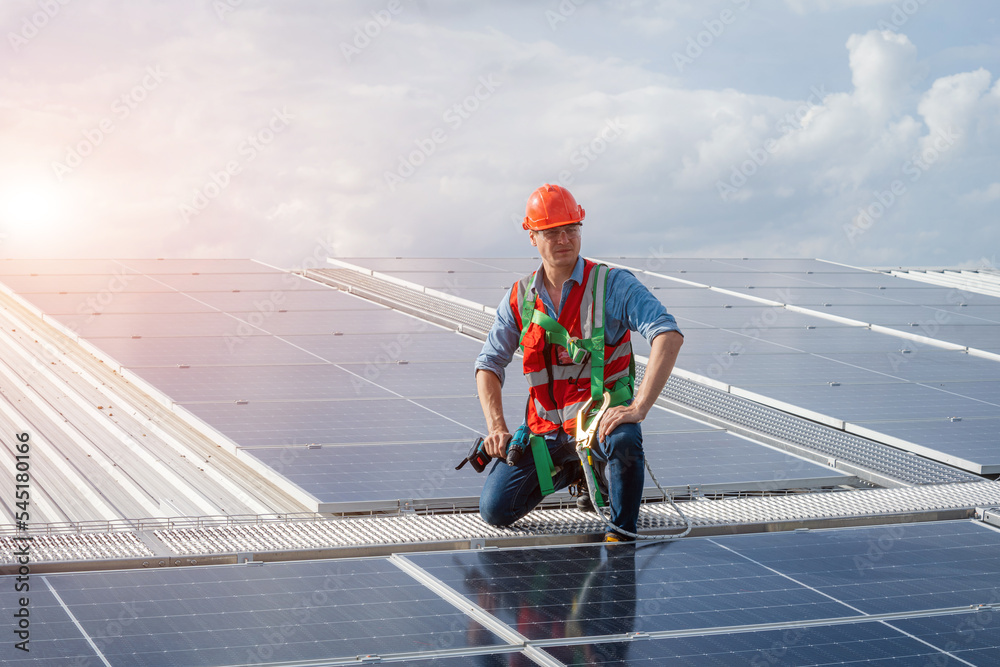 custom made wallpaper toronto digitalTechnician wearing safety harness belt using drill during installing the solar panels on roof structure of building factory.