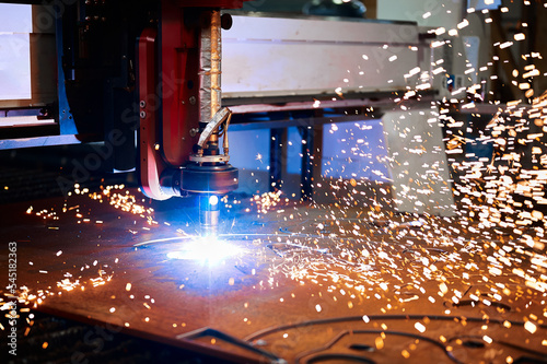 Bright flame sparks fly during plasma cutting out of details