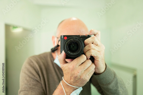 bold man with a leica camera in mirror (q2)  © eachfilm