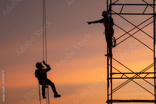 rope access, foreman operation control training the abseiling from the height silhouette . photo