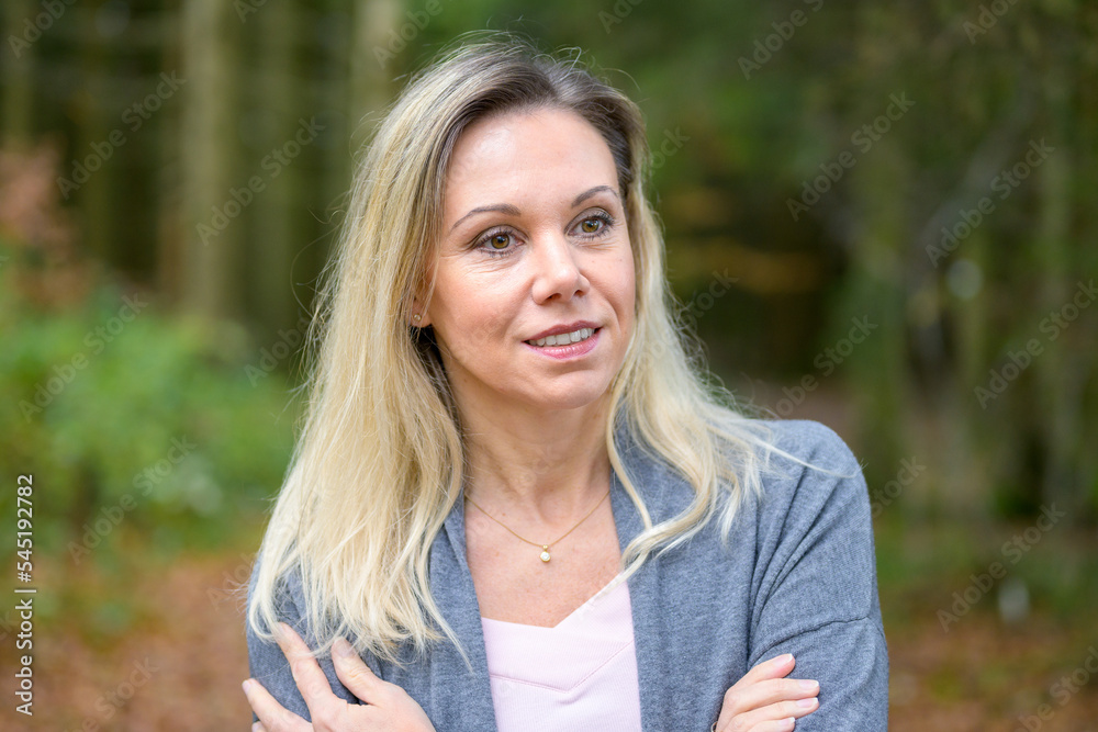 Woman with crossed arms in a forest