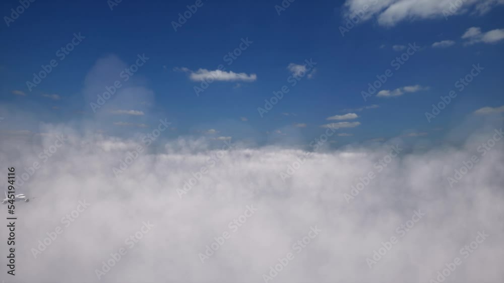 Airplane flying through white clouds against a blue sky. Airplane flying through white clouds against a blue sky.
