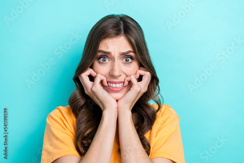 Closeup photo of young adorable pretty cute nice girl bite lips nails nervous toothy funny face fail deadline worker isolated on aquamarine color background