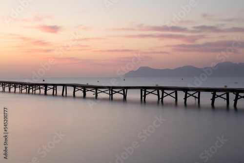 Long pier in the sea at sunset © Frozen Moment/Wirestock Creators