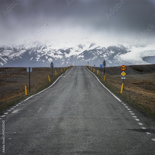 Highway in Iceland with scenic mountains and a gloomy cloudscape in the background