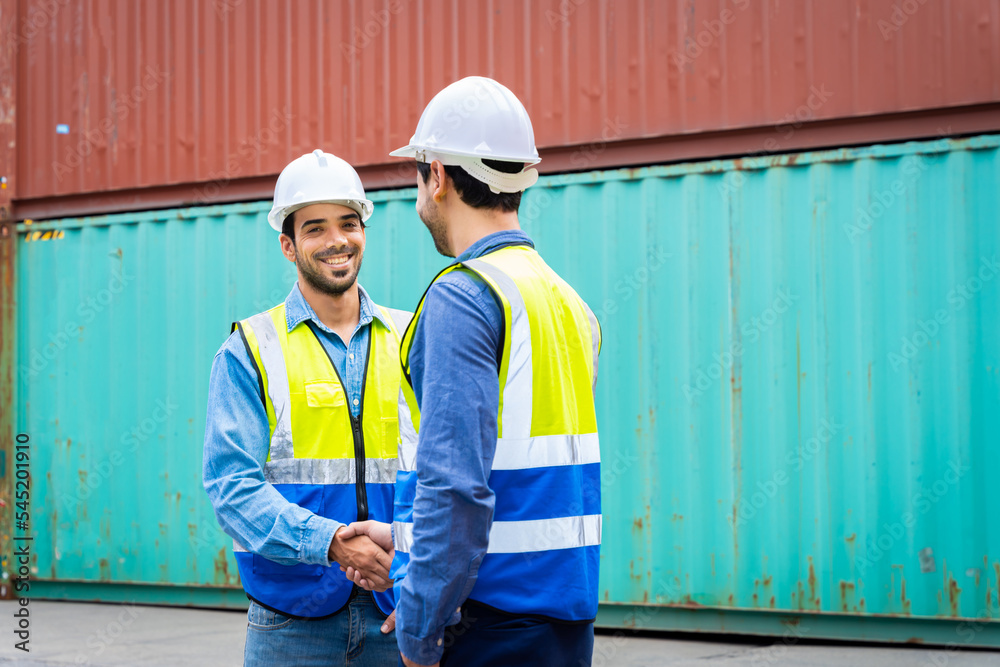 Two male engineers in a container shipping company Consulting to check the order for the container that is responsible