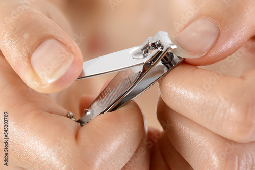 Fotografia Woman at manicure cuts fingernails with nail clippers