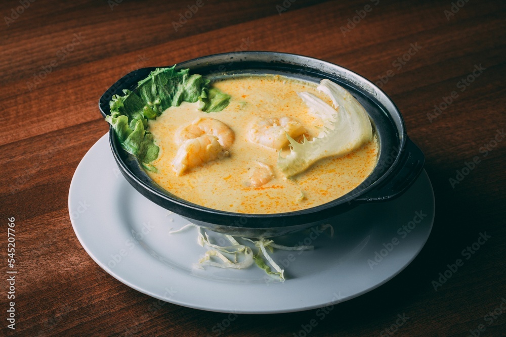 Closeup shot of a soup with shrimp and lettuce