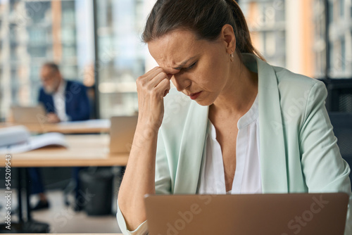 Female businessman with headache working in office