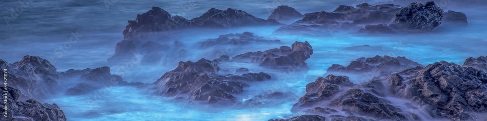 Panoramic long exposure of fog, mist on rocks, a purple background