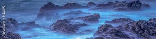 Panoramic long exposure of fog, mist on rocks, a purple background