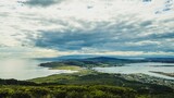 Panoramic view of a green forest against the sea in Invercargill, New Zealand on a cloudy day